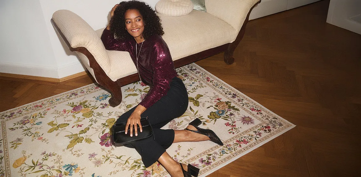 Elegante maglia a maniche lunghe color bordeaux su jeans scuri.