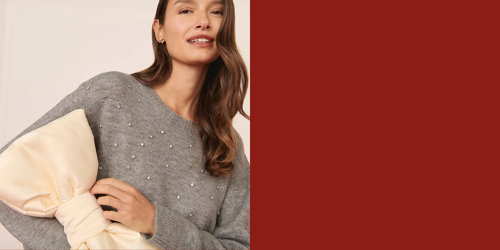 Maglione grigio elegante con perle decorative.