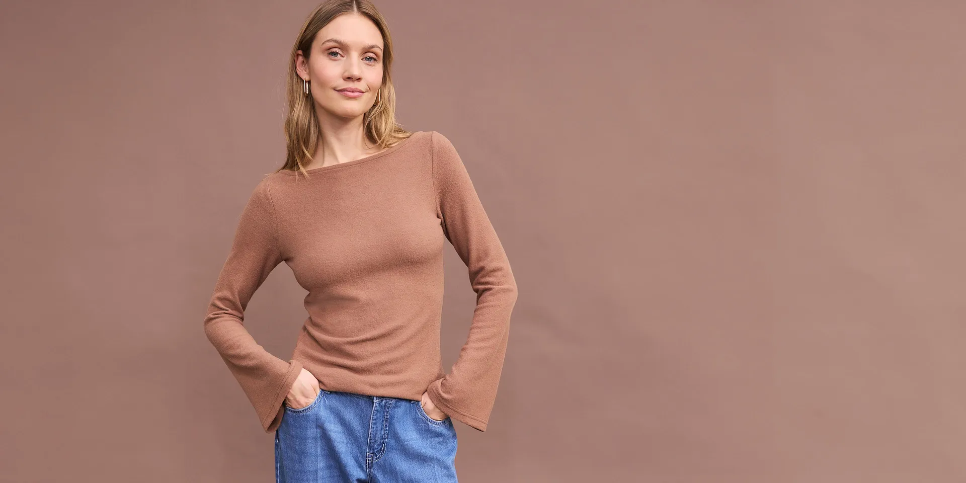 Maglia marrone a maniche lunghe con comodi jeans blu.