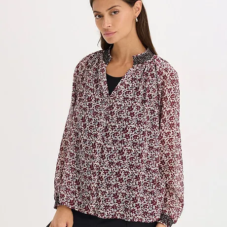 Blusa con motivo floreale in nero, rosso e bianco.