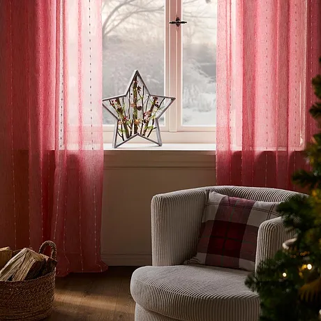 Tende rosa che incorniciano la finestra.