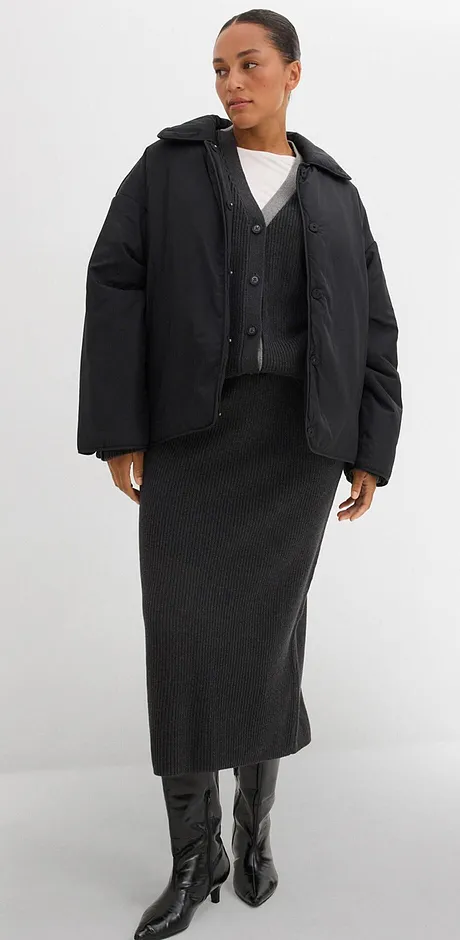 Giacca trapuntata, gonna lunga e stivali di pelle. Sotto, un semplice top bianco.