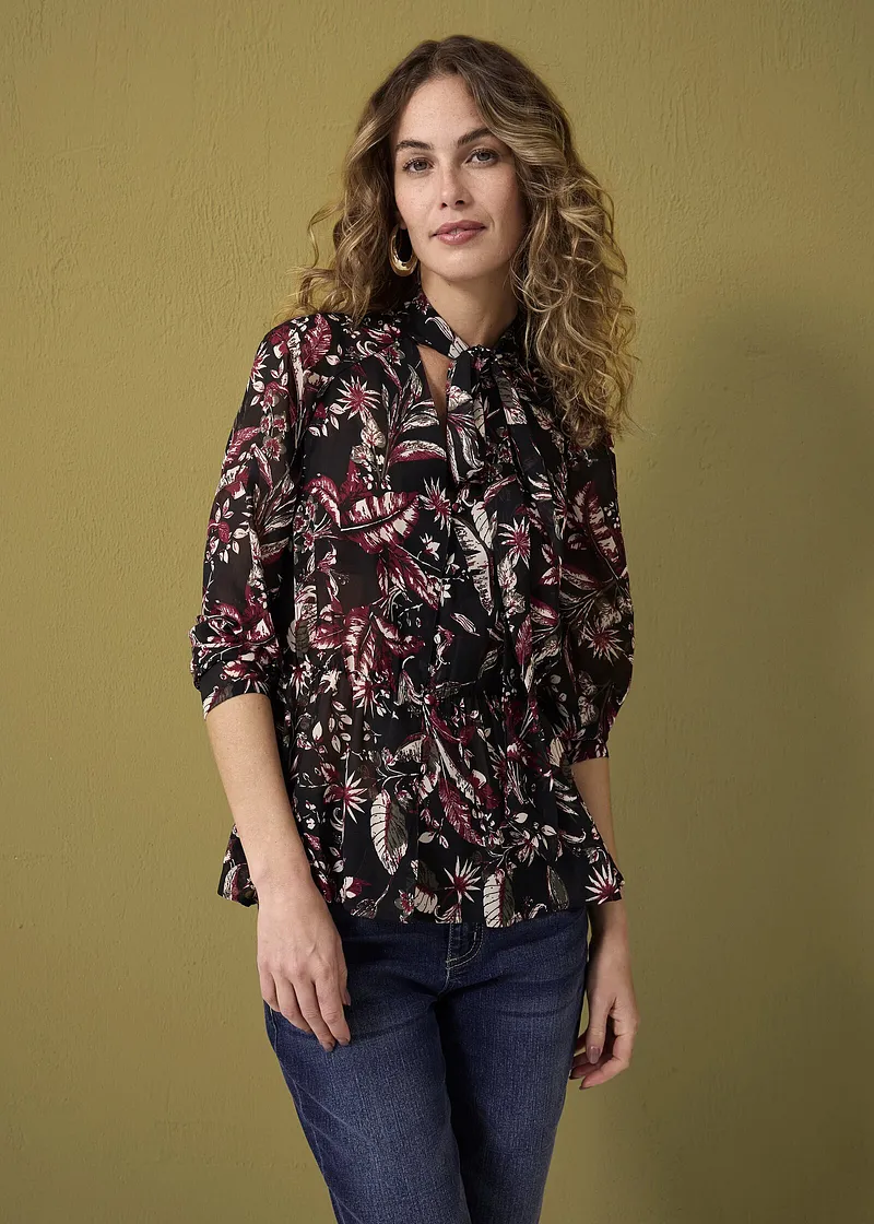 Blusa floreale con collo con fiocco, abbinata a jeans classici. Stile boho chic discreto per tutti i giorni.