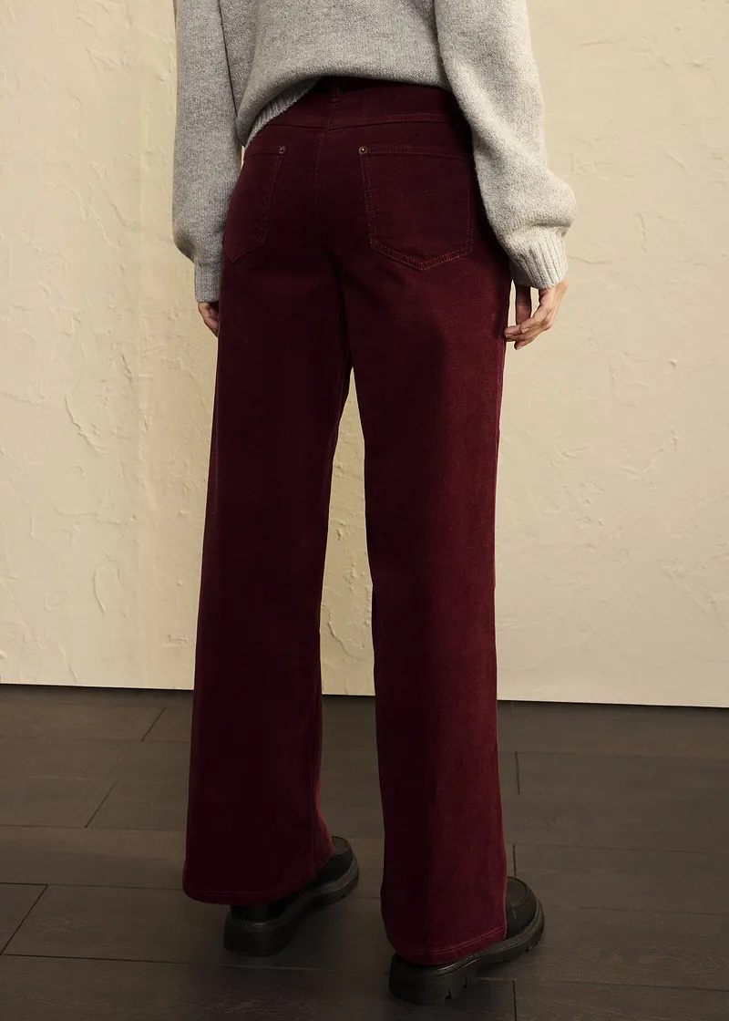 Elegante abbinamento tra maglione grigio e pantaloni di velluto color bordeaux.