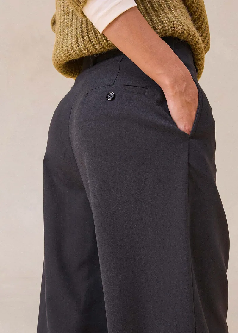 Pantaloni neri con tasche, abbinati a un caldo maglione lavorato a maglia.
