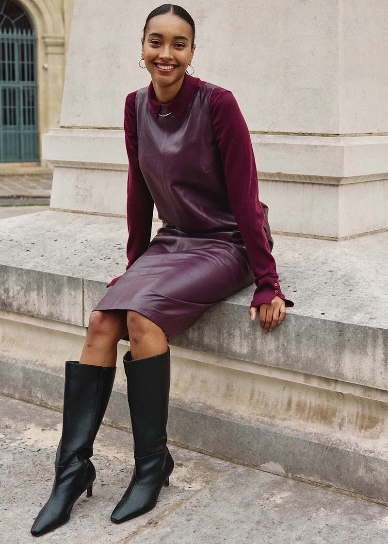 Elegante combinazione di maglione viola, gilet grigio e abito viola scuro.