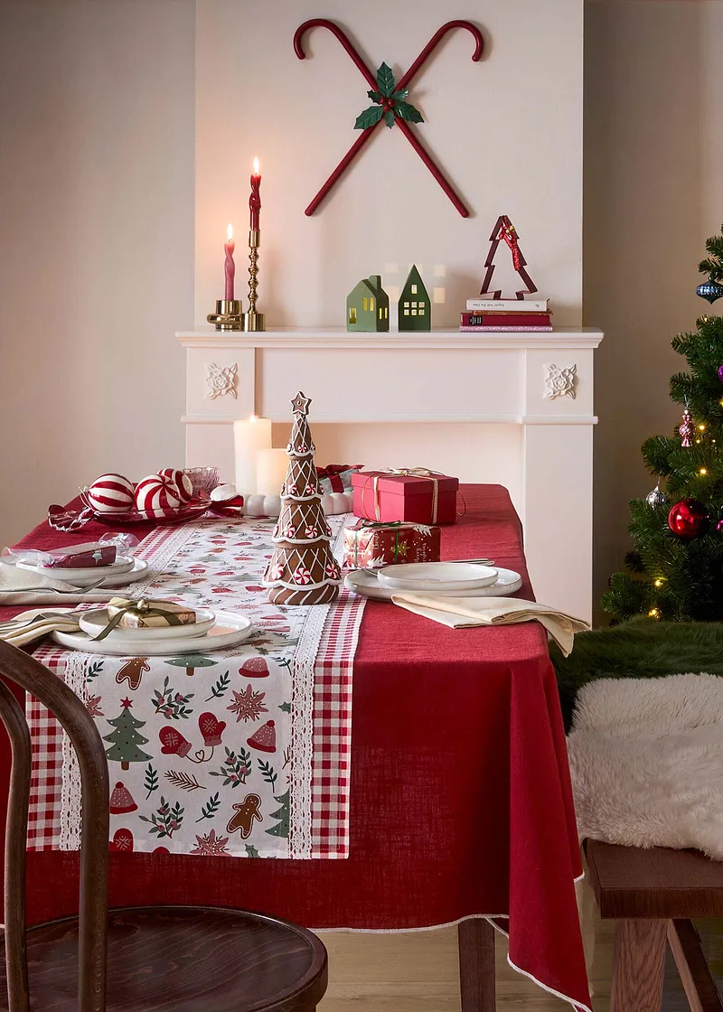 Una tovaglia festiva con motivi natalizi decora la tavola imbandita.