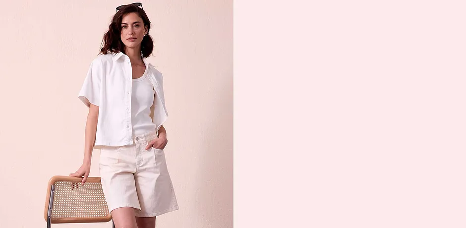 Outfit estivo in colori chiari: camicia a maniche corte, t-shirt e pantaloni bermuda con tasche.