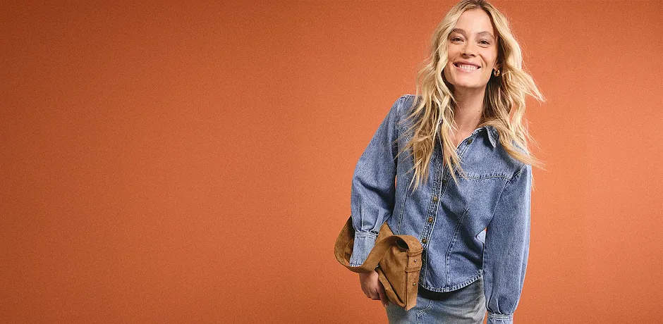 Look denim casual con camicia di jeans blu, jeans abbinati e borsa a tracolla marrone per una giornata rilassante.