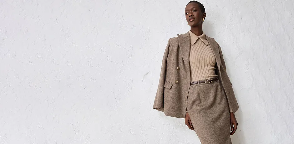 Giacca beige con maglione lavorato a maglia e gonna abbinati.
