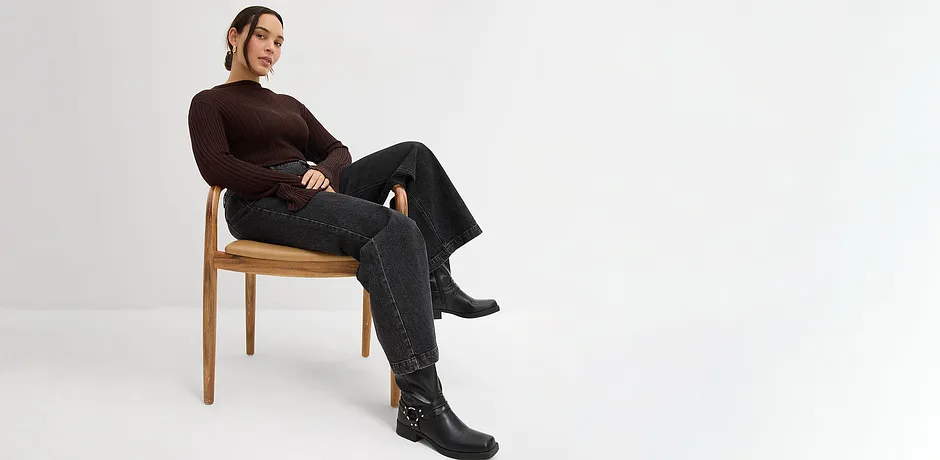 Maglia a maniche lunghe, jeans neri e stivali di pelle.