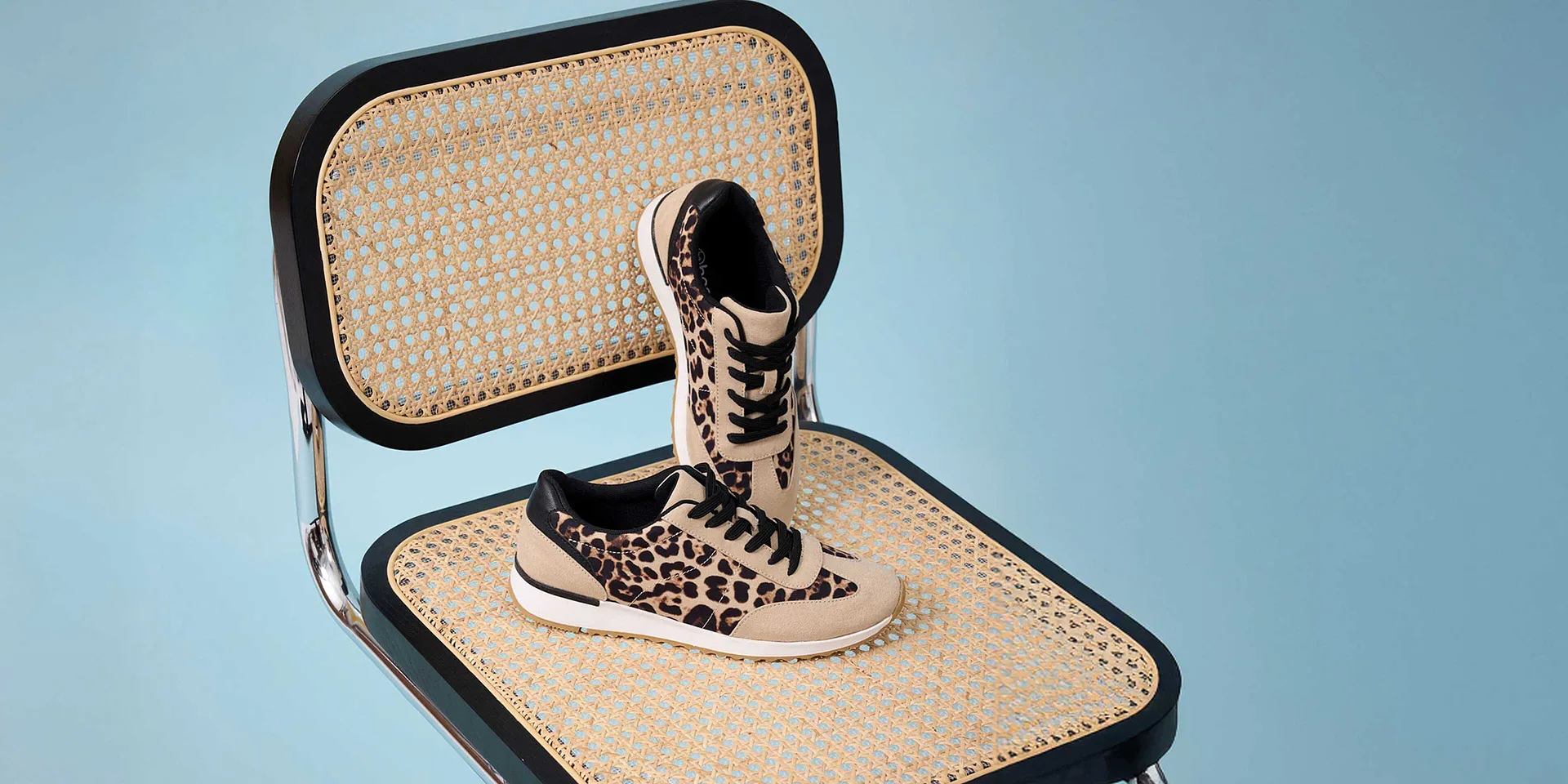 Eleganti sneakers leopardate su sfondo intrecciato.