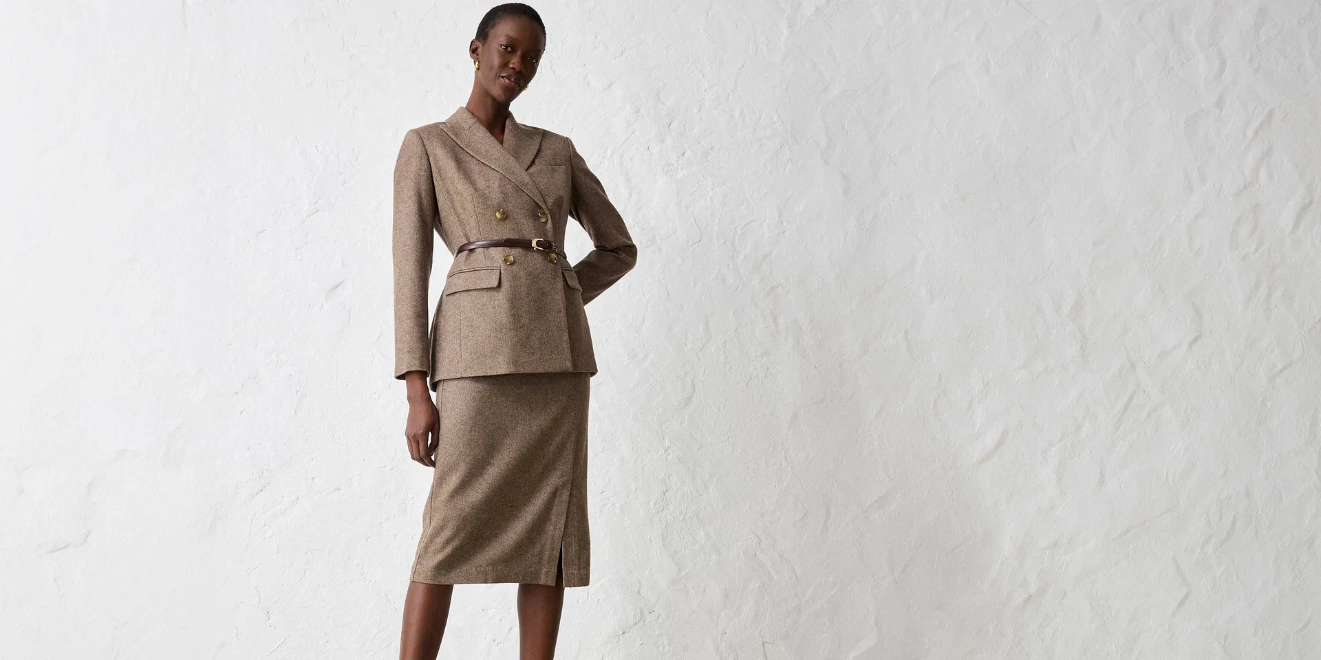 Giacca beige con cintura, abbinata a gonna coordinata.