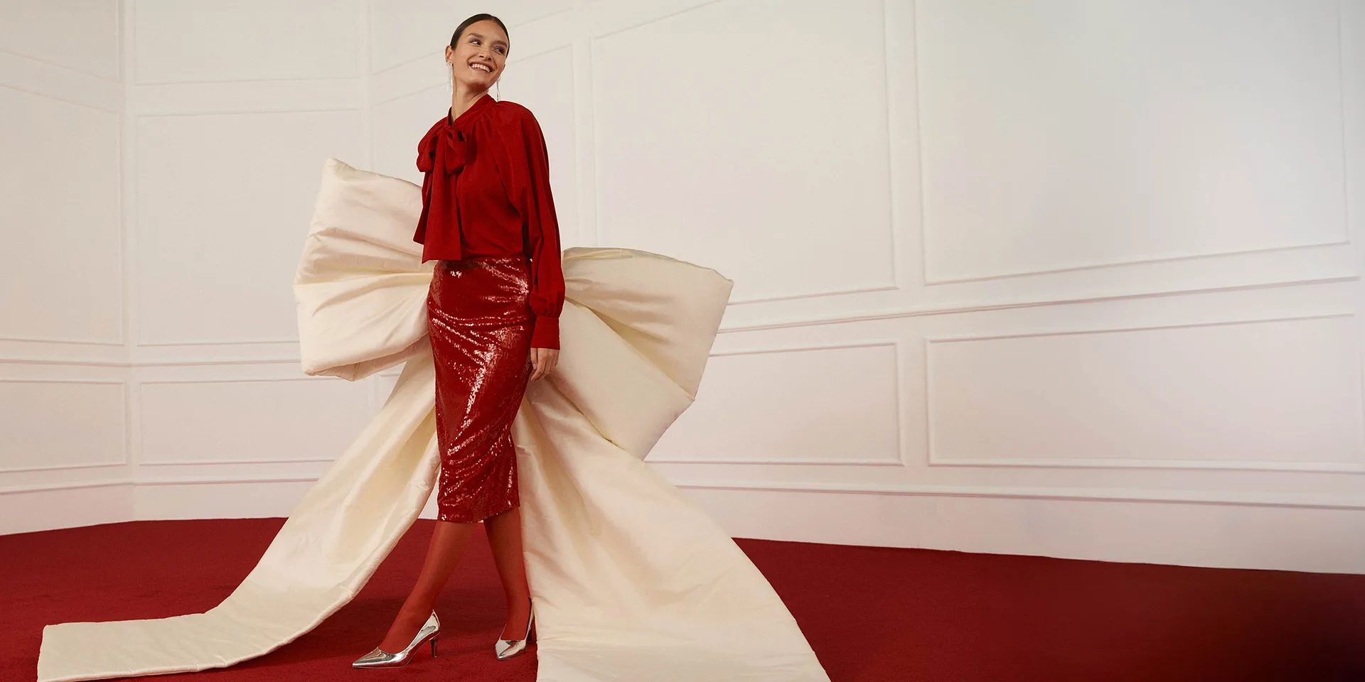 Elegante blusa rossa abbinata a una gonna lucida.