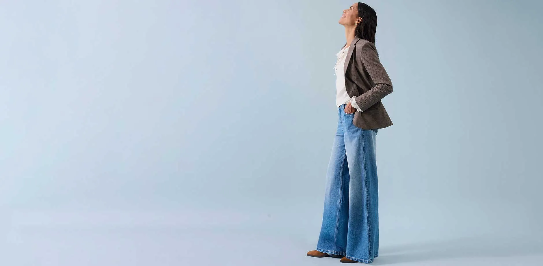 Jeans ampi, top chiaro e blazer beige per uno stile rilassato.