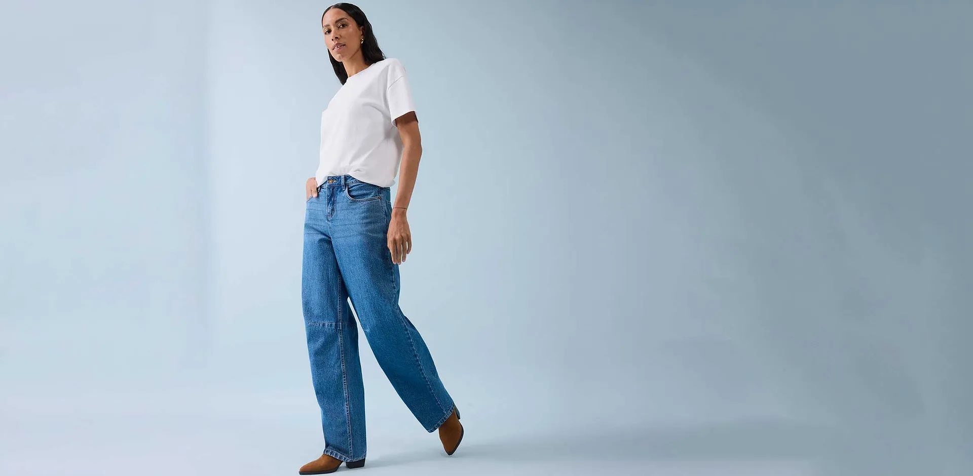 Classica t-shirt bianca abbinata a jeans ampi e scarpe marroni.