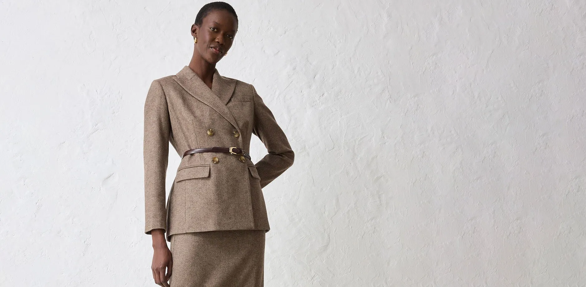 Giacca beige con cintura, abbinata a gonna coordinata.