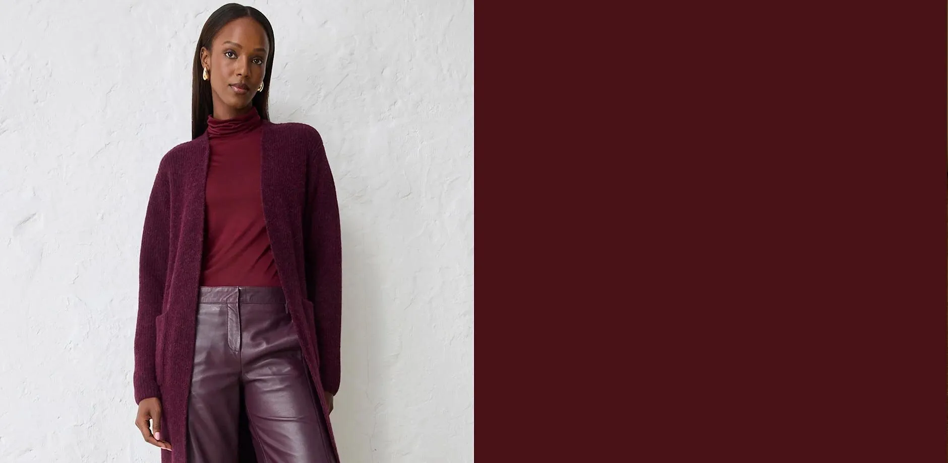 Cardigan lungo in maglia, dolcevita abbinato e pantaloni in pelle lucida in viola scuro.