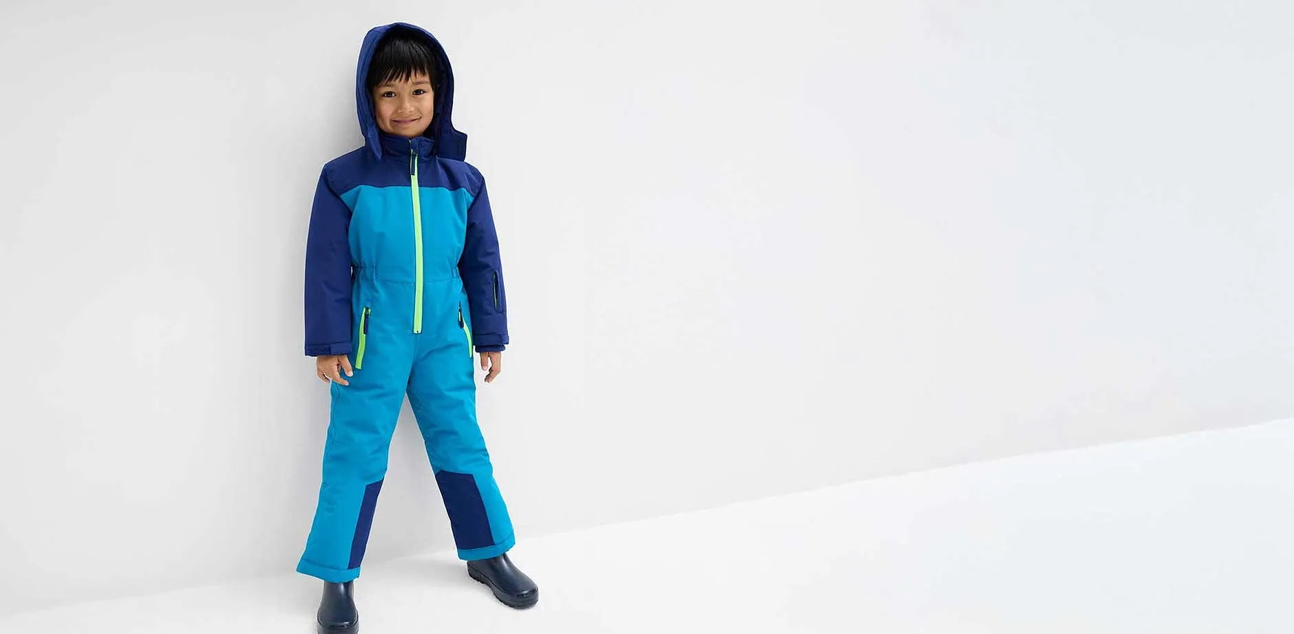 Bambino con tuta da neve.