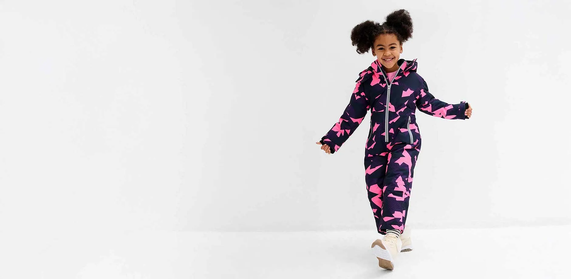 Bambina con tuta da neve.