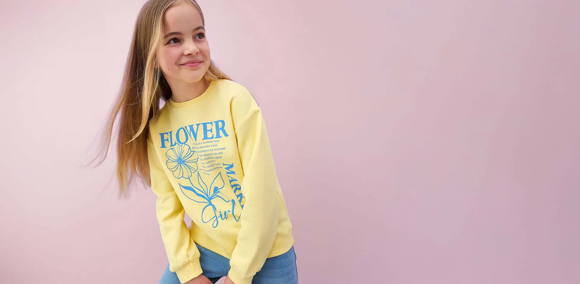 Maglia gialla a maniche lunghe con motivo floreale e scritta.