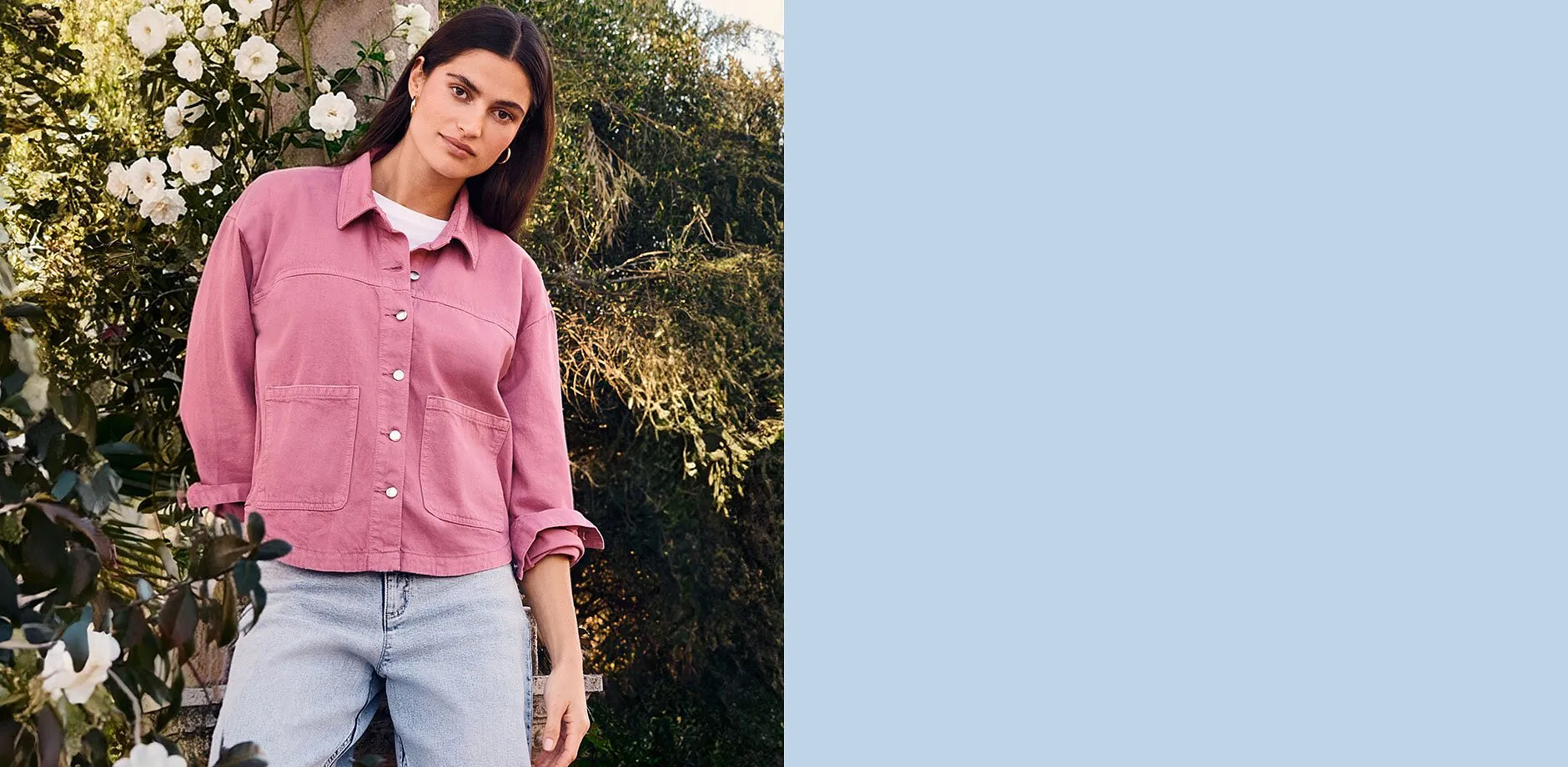 Giacca rosa con grandi tasche sopra una camicia bianca, abbinata a jeans chiari.