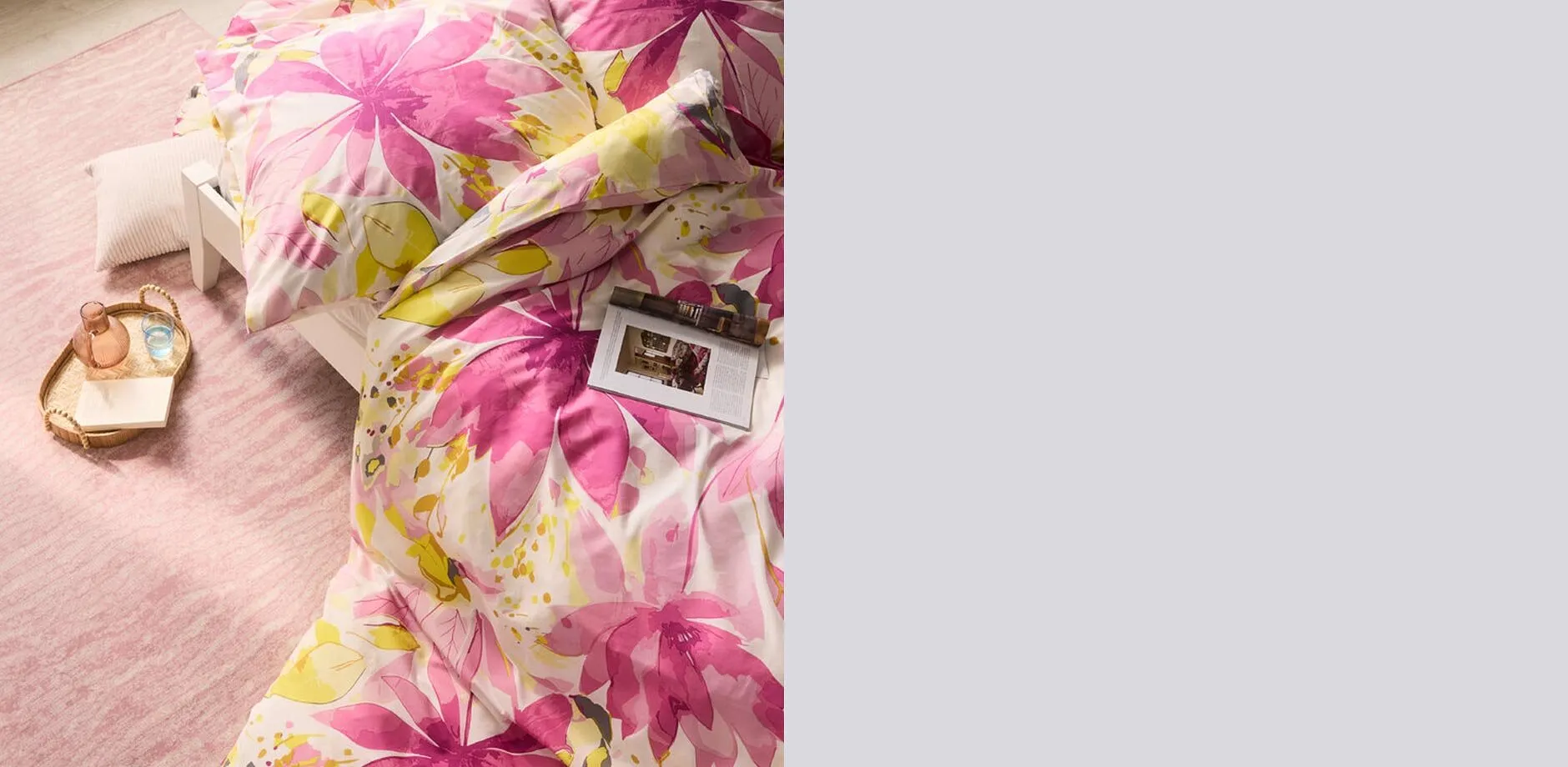 Biancheria da letto con grandi motivi floreali rosa e gialli.