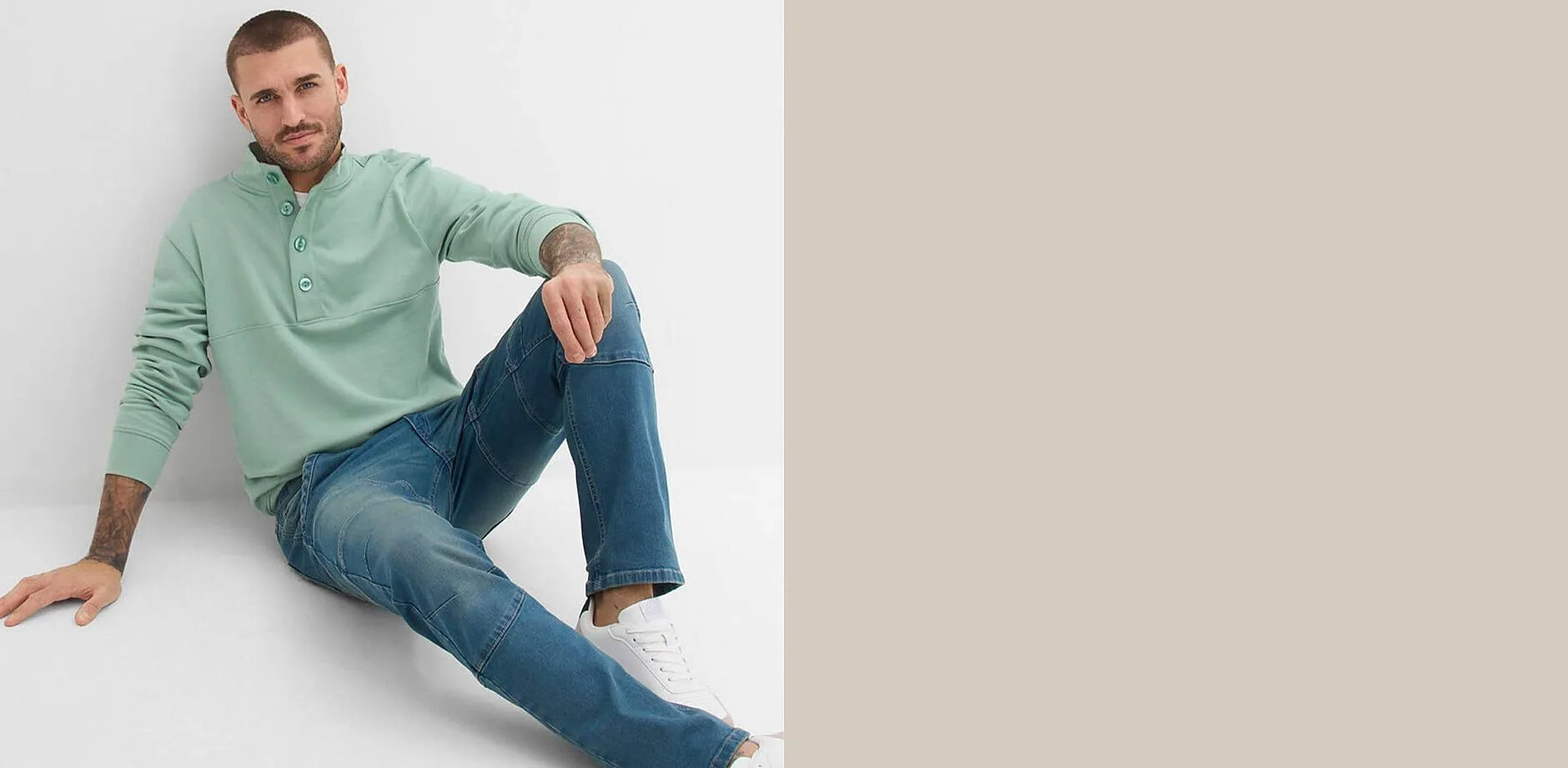 Felpa verde menta con chiusura a bottoni sul collo, abbinata a jeans blu.