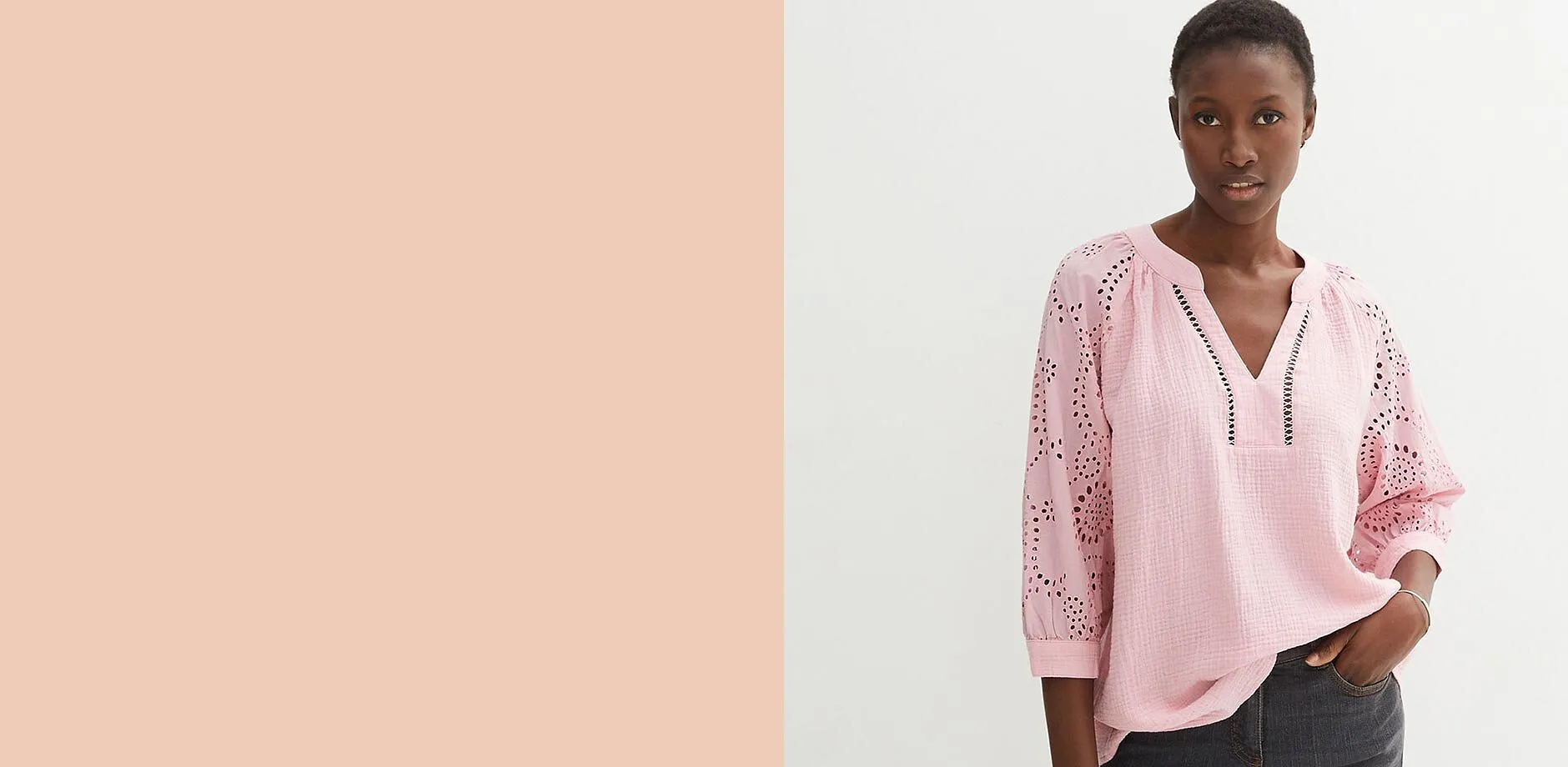 Tunica rosa con ricami traforati e scollo a V, abbinata a jeans scuri.