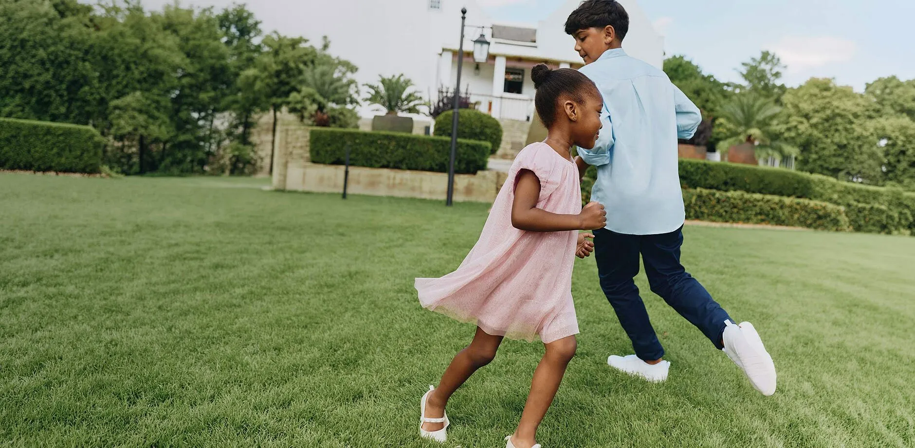 Camicia azzurra, pantaloni blu, vestito rosa e scarpe bianche per la festa.