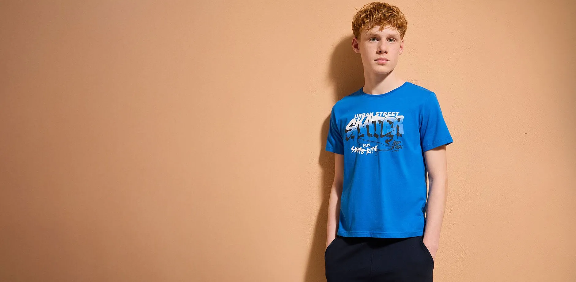 Look casual: maglietta blu, jeans chiari e comode sneakers. Una combinazione casual per tutti i giorni.