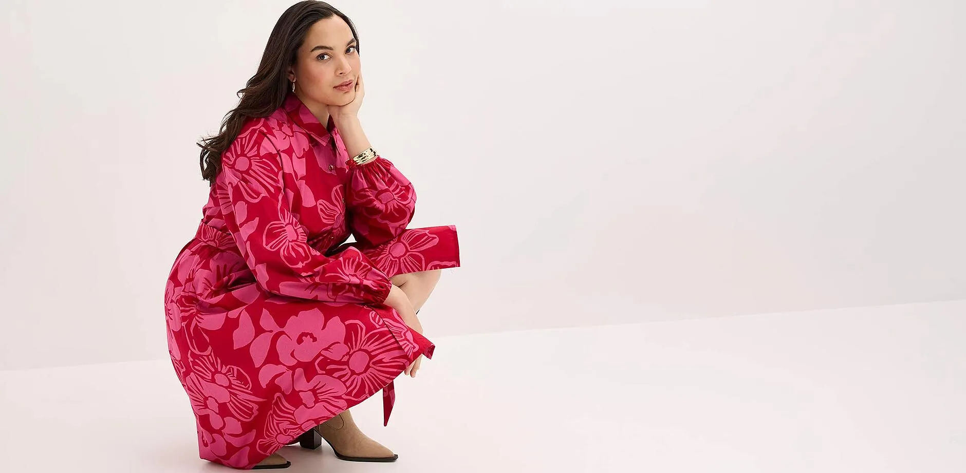 Abito rosso appariscente con motivo floreale, maniche lunghe e colletto. 