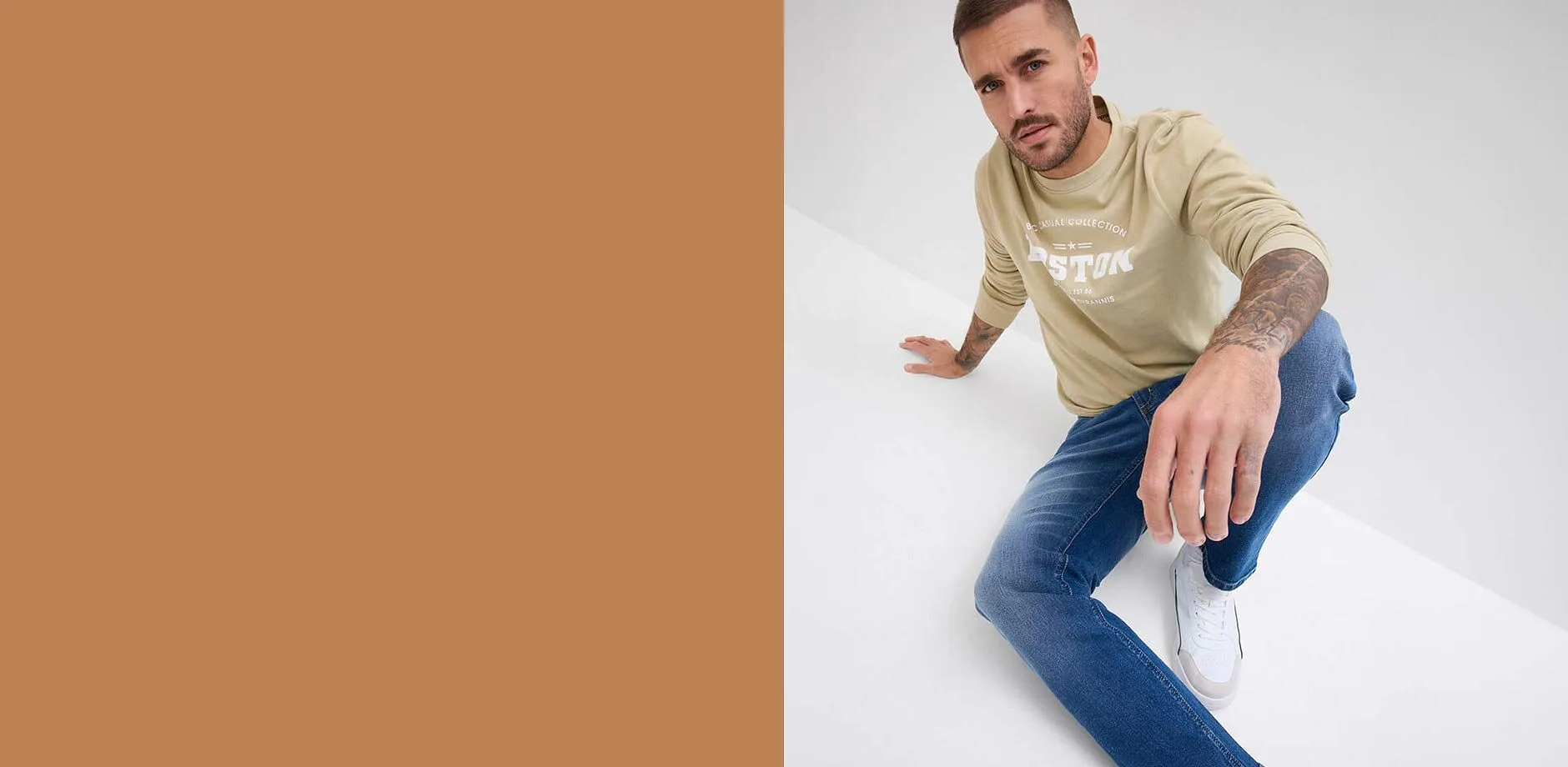 Jeans regular fit abbinati a una maglia beige con scritta.