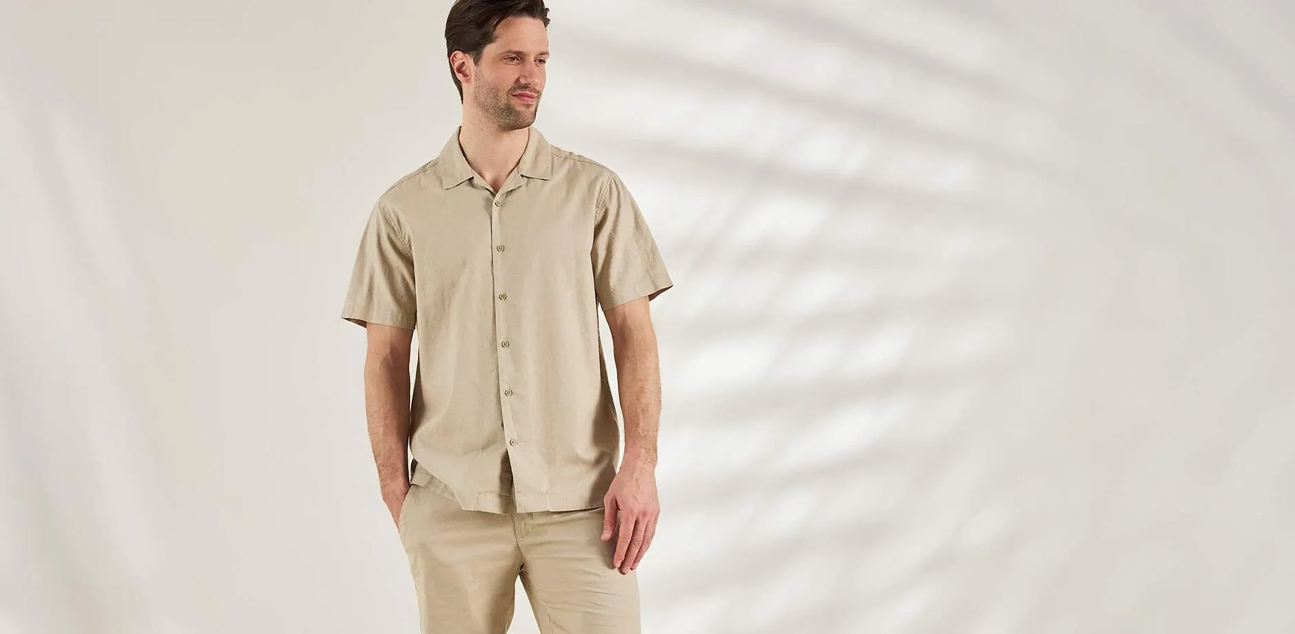 Outfit composto da camicia a maniche corte beige e pantaloni abbinati, per un look casual.