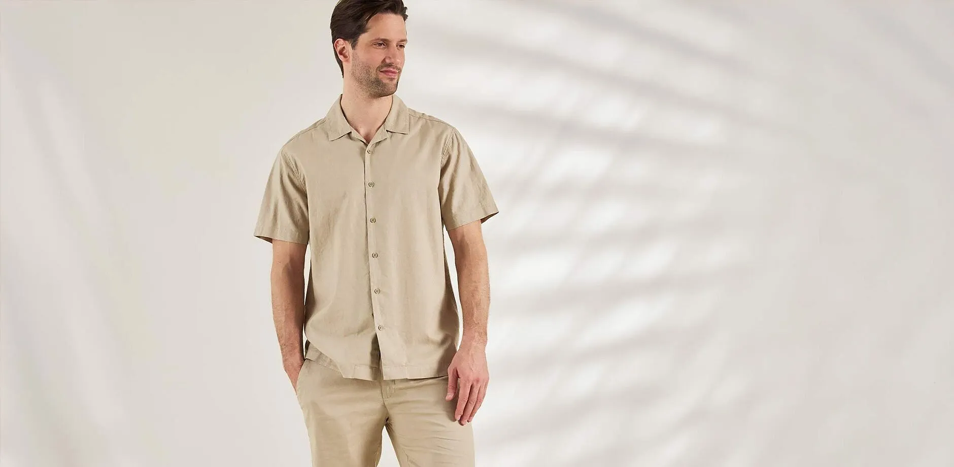 Outfit composto da camicia a maniche corte beige e pantaloni abbinati, per un look casual.
