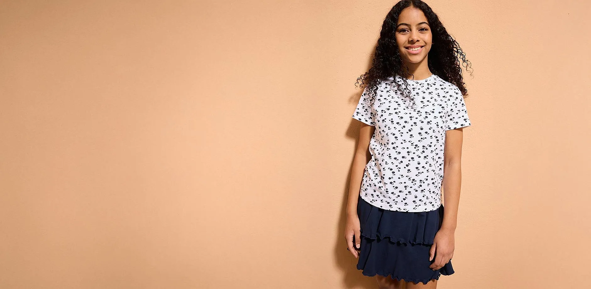 Una ragazza indossa una maglietta bianca in fantasia.