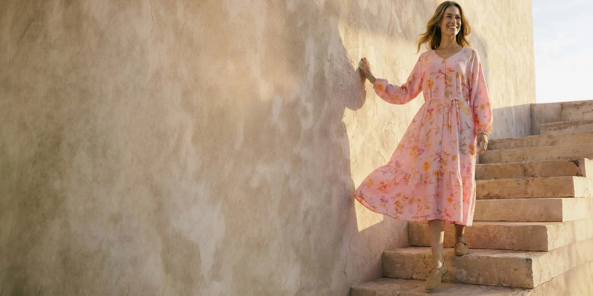 Delicato abito rosa con motivi floreali.