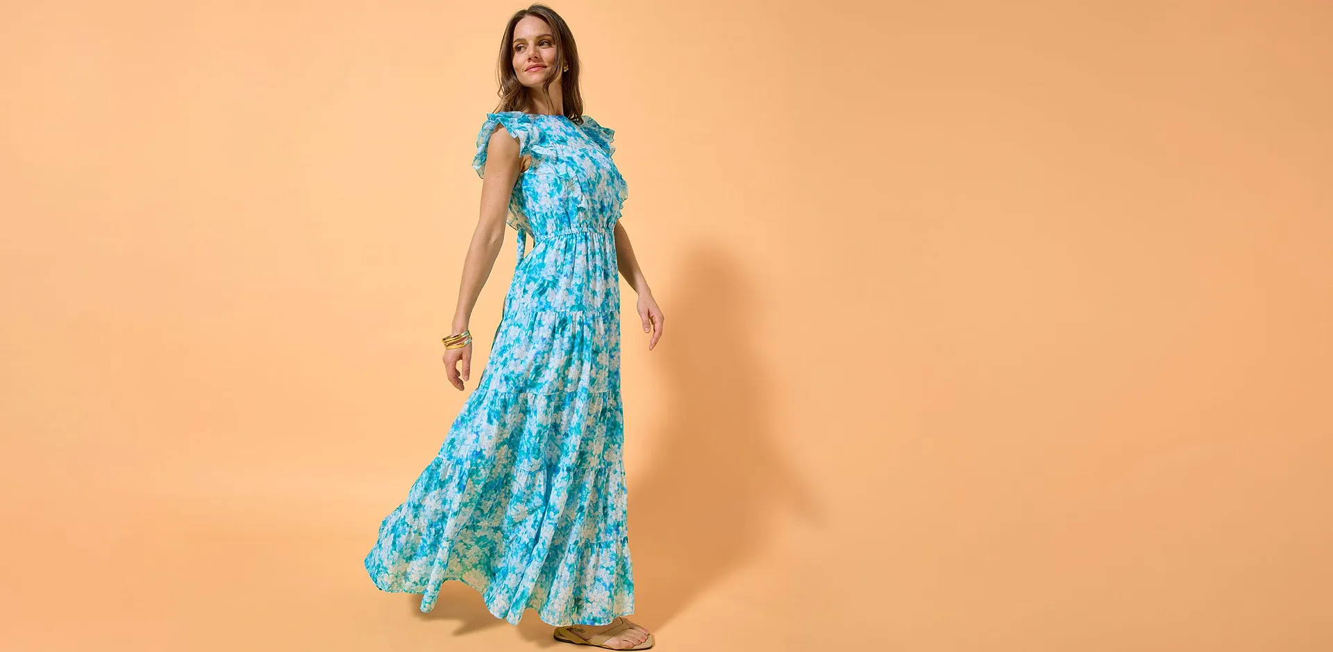 Abito lungo blu con motivo floreale tropicale.