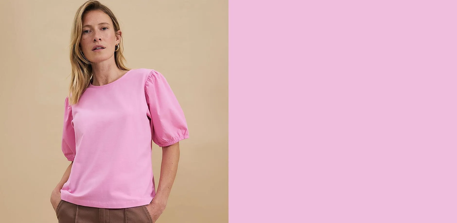 Maglia rosa con maniche a palloncino abbinata a pantaloni beige.