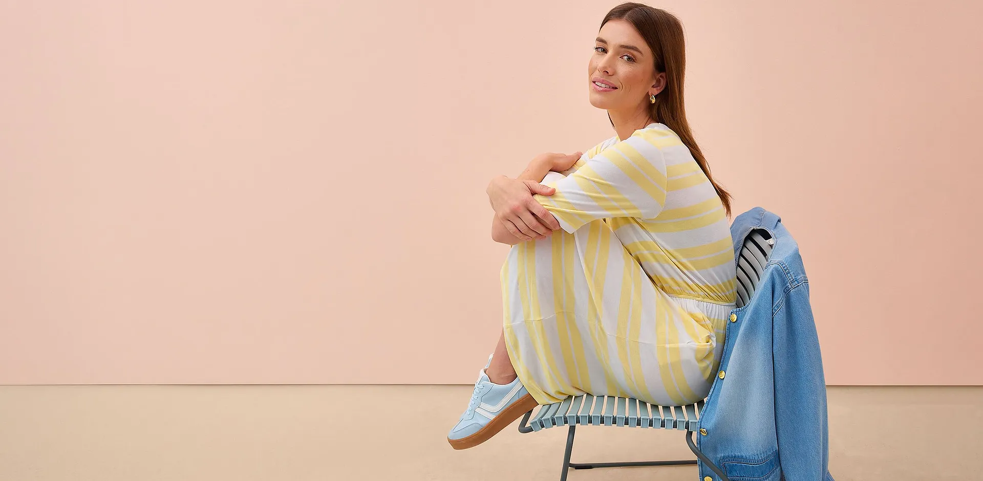 Una donna indossa un vestito a righe gialle e bianche.