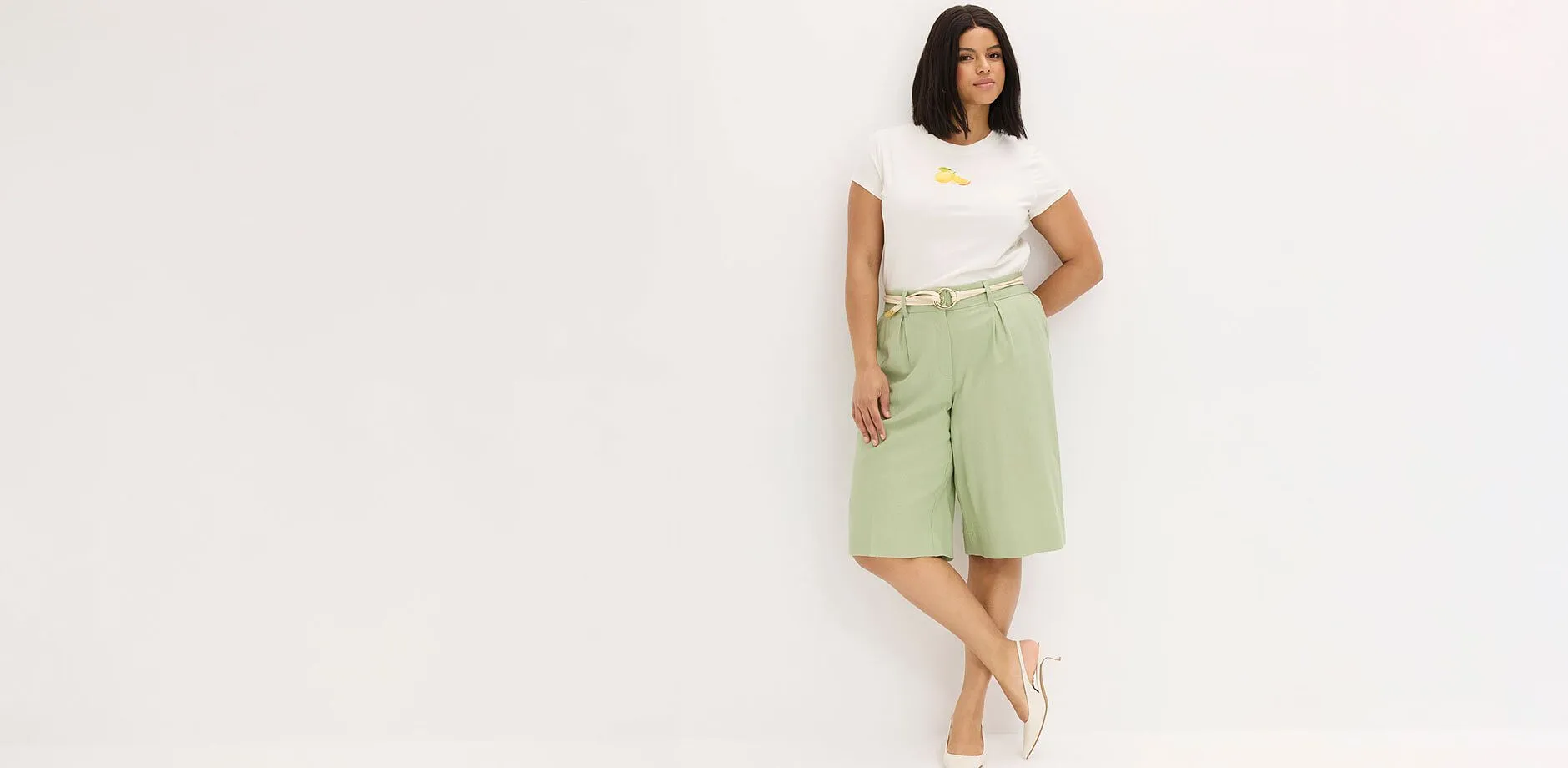 Maglietta bianca, bermuda verde menta e sandali beige.