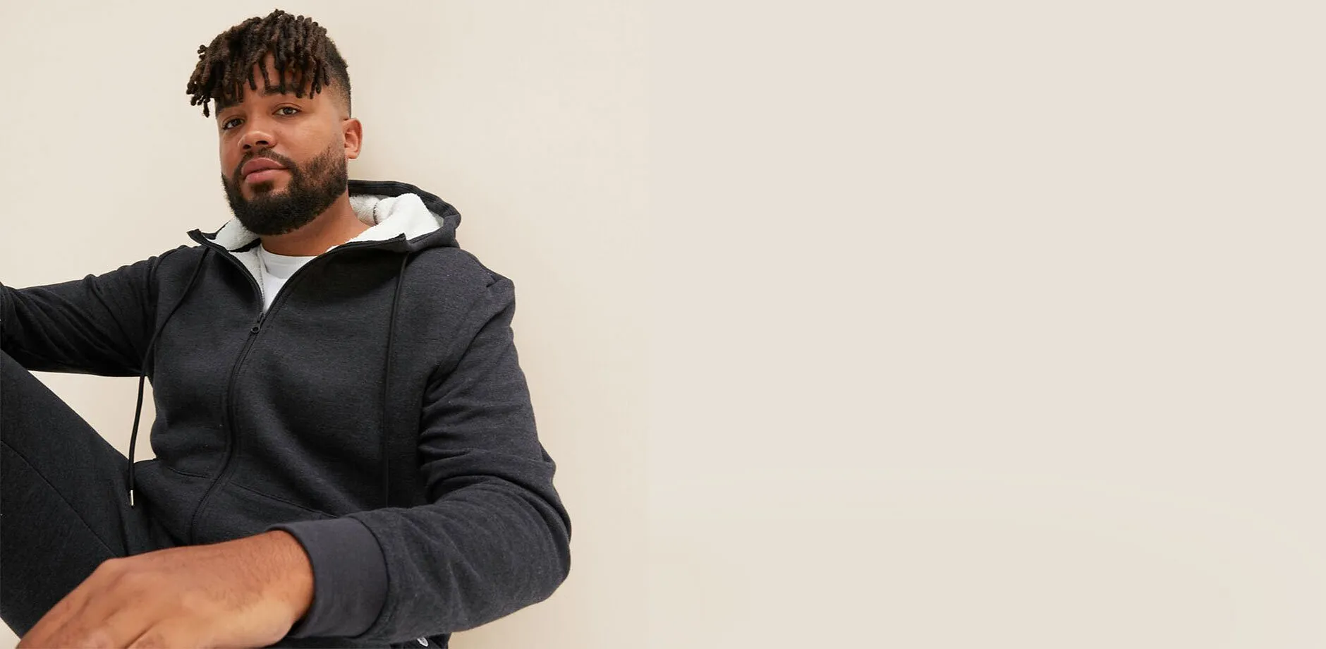 Una giacca con cappuccio grigio scuro con fodera bianca.