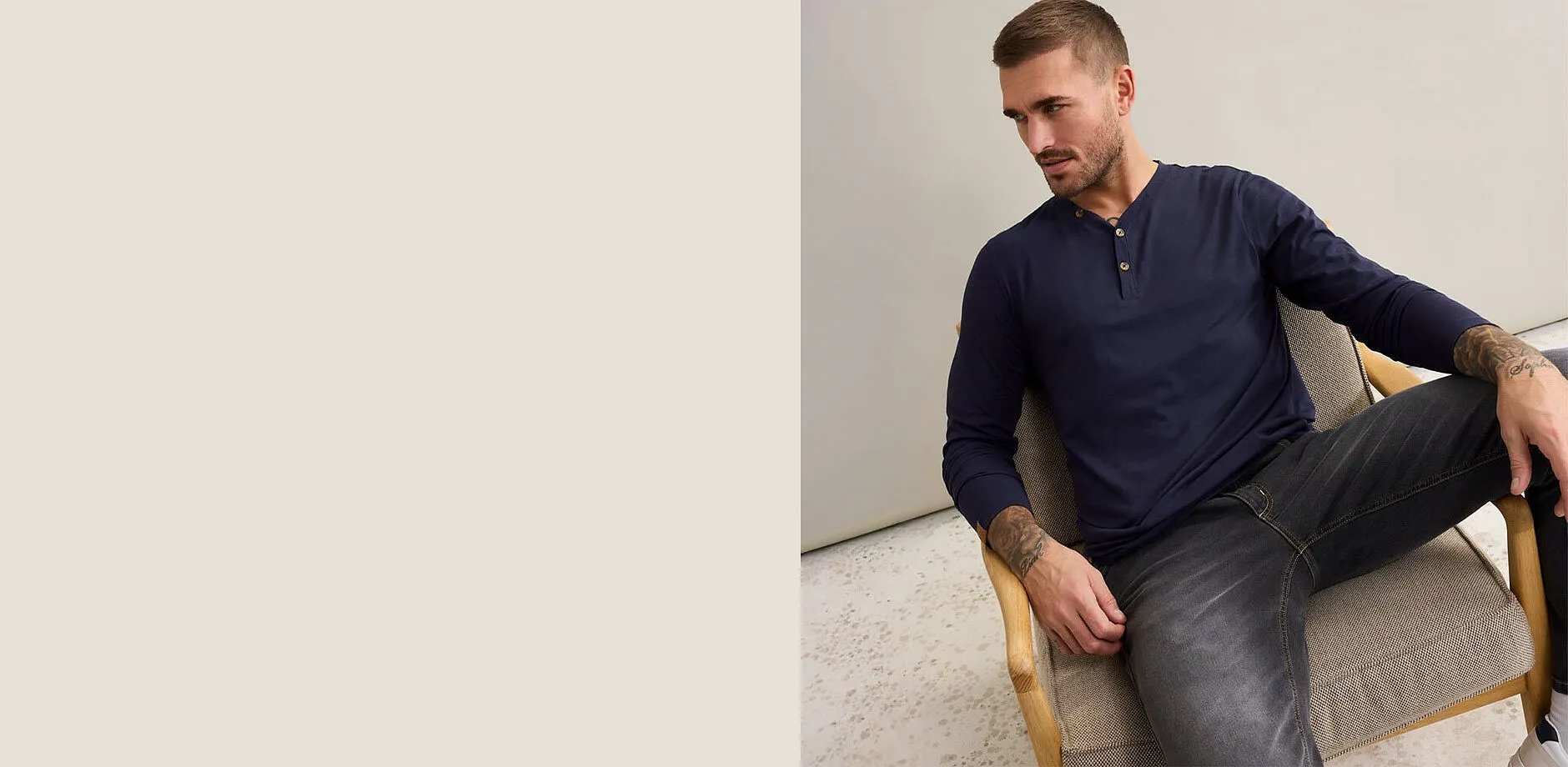 Maglia a maniche lunghe blu scuro con abbottonatura, abbinata a jeans grigi.