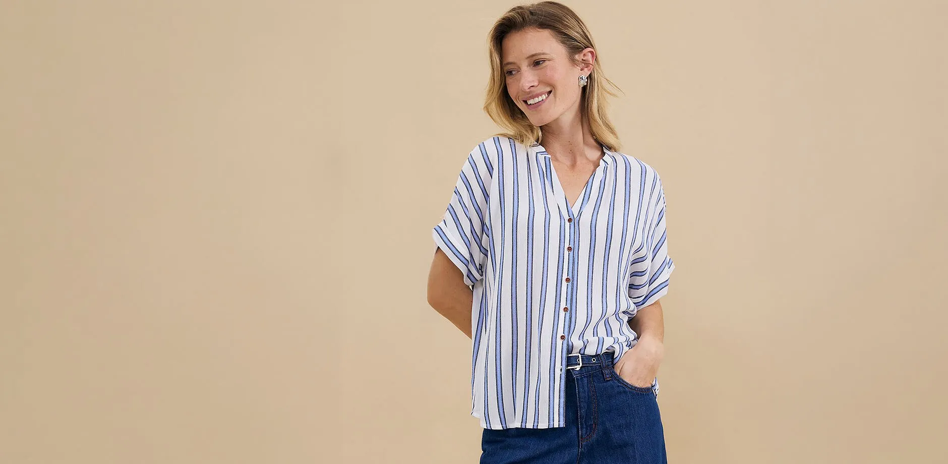 Una camicetta casual a righe con maniche corte abbinata a un classico paio di jeans scuri.