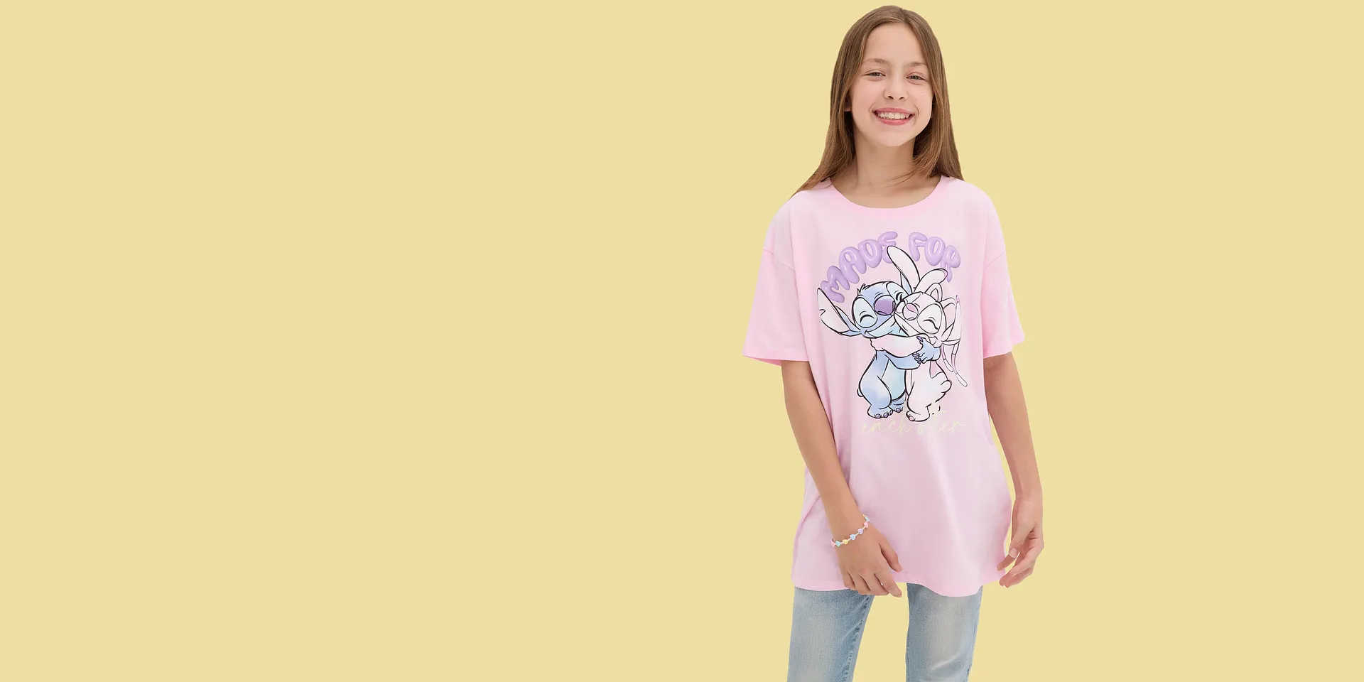 Una maglietta rosa con un simpatico motivo a fumetti dona un look allegro e giocoso.