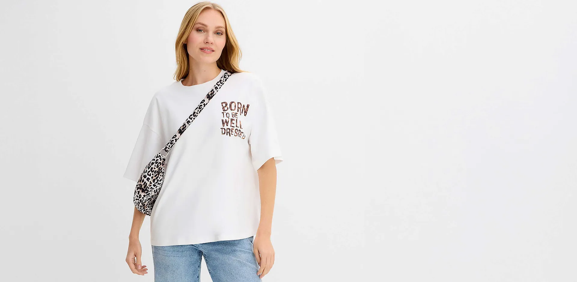 Maglietta bianca con stampa e dettagli leopardati, abbinata a un paio di jeans blu casual.