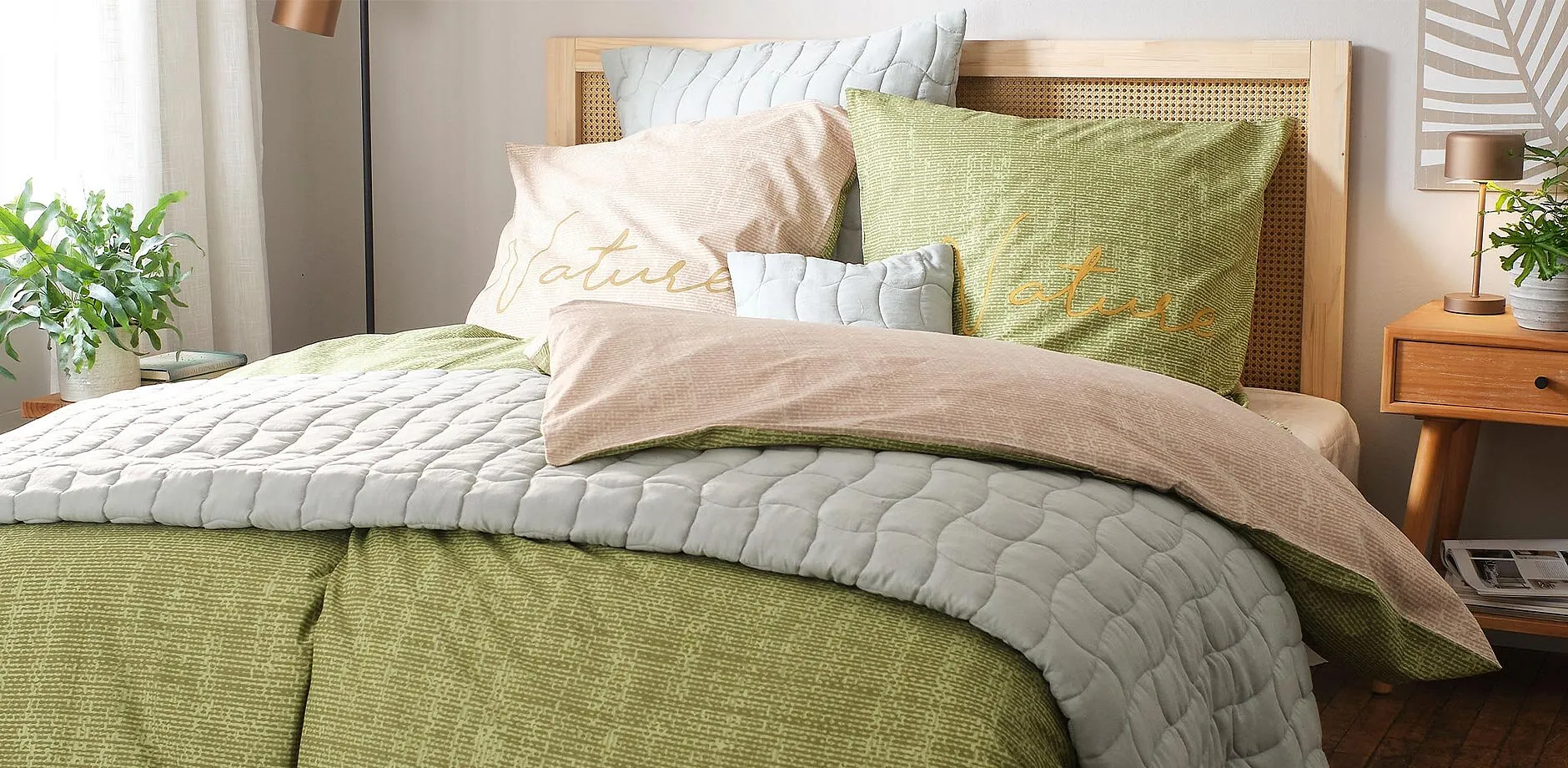 Le lenzuola verdi e grigie, abbinate a cuscini di vari colori, creano un'atmosfera accogliente in camera da letto.