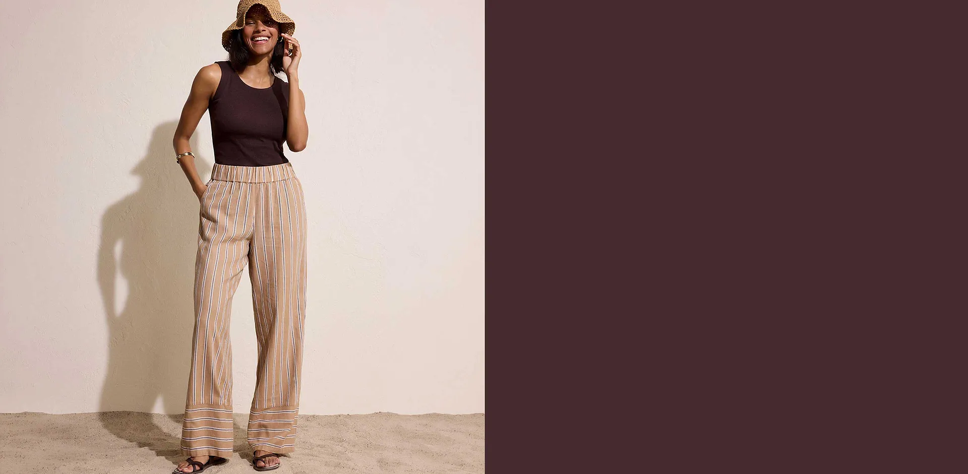 Un top nero abbinato a pantaloni leggeri a righe nei caldi toni della terra, per un look estivo disinvolto.
