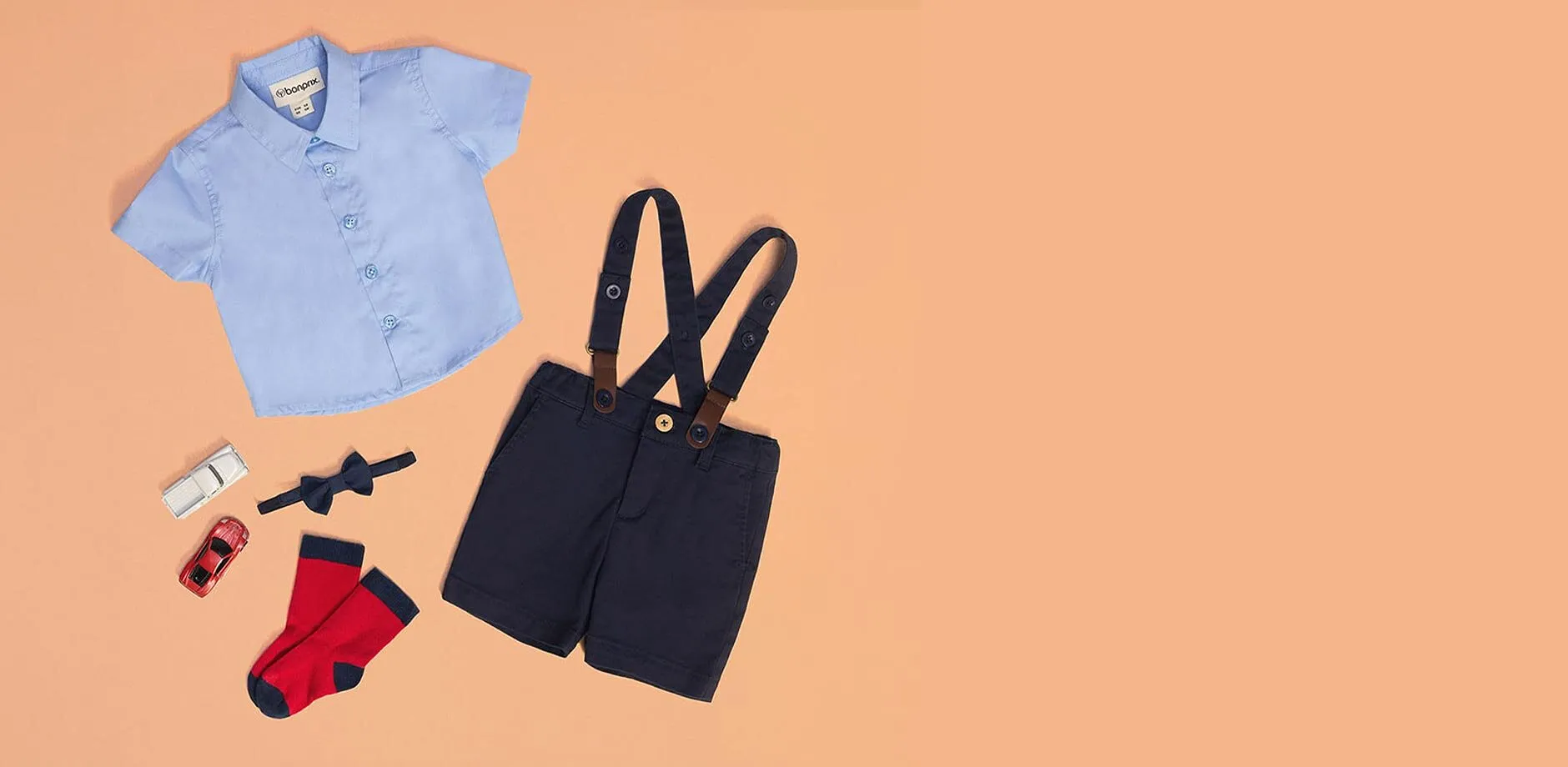 Camicia blu, pantaloncini con bretelle neri e calzini rossi per neonati.