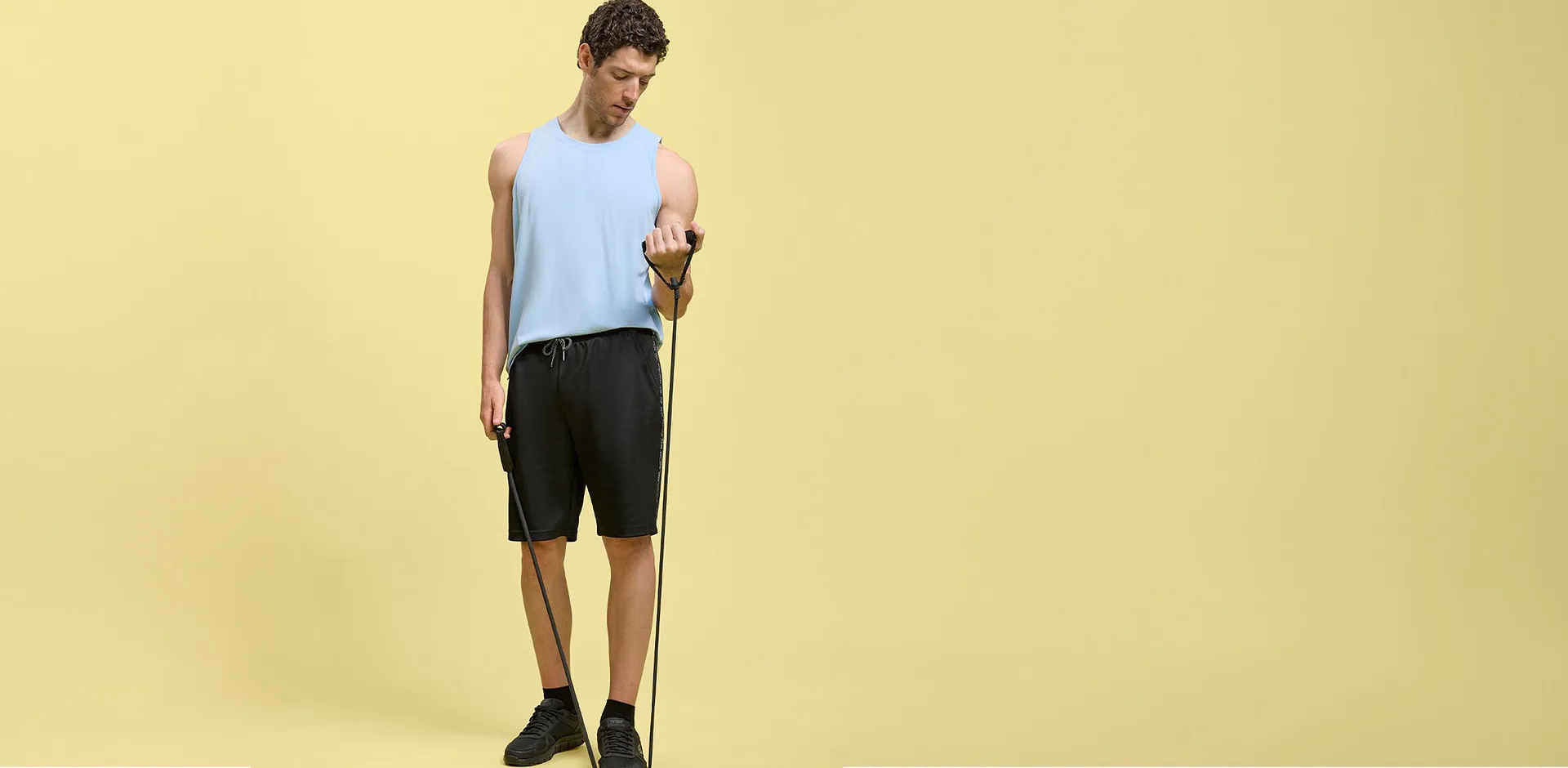 Canotta azzurra, pantaloncini neri e scarpe da ginnastica: l'abbigliamento perfetto per l'allenamento.